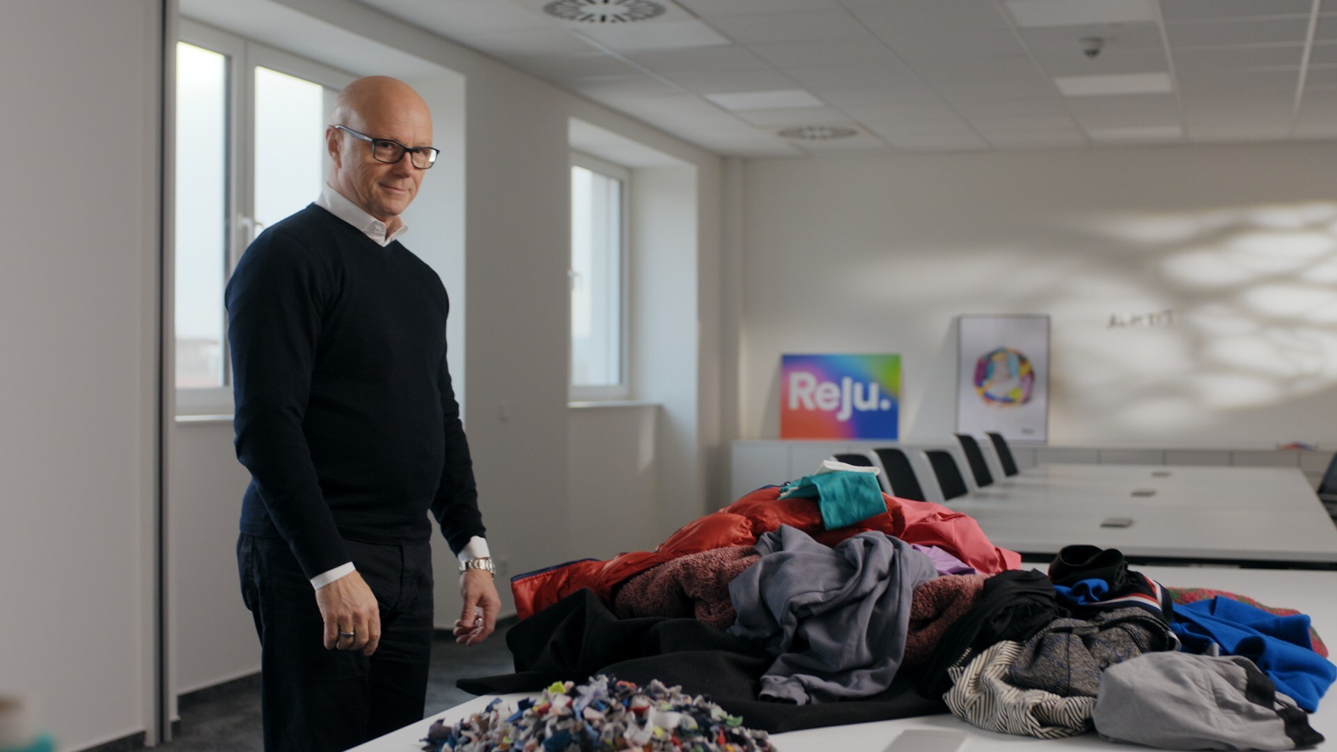 Patrik Frisk, CEO of Reju, stands alongside post-consumer textile waste. The textile-to-textile regeneration company is featured in 'Fashion Redressed', a BBC StoryWorks series addressing the textile waste crisis.